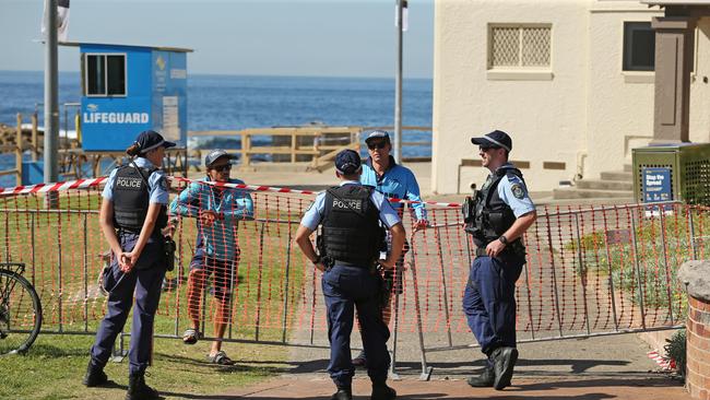 Members of the public received conflicting orders from police at the reopened beach yesterday. Pictures: Richard Dobson