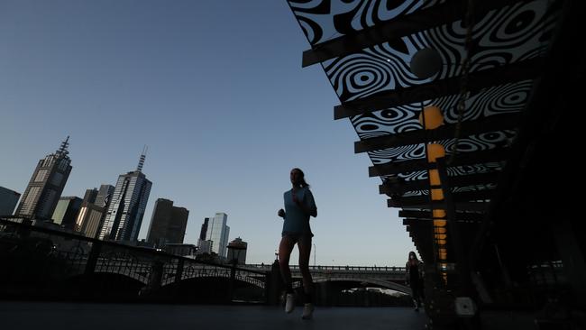 A woman runs along a deserted Southbank in Melbourne on Thursday. Picture: Darrian Traynor/Getty Images