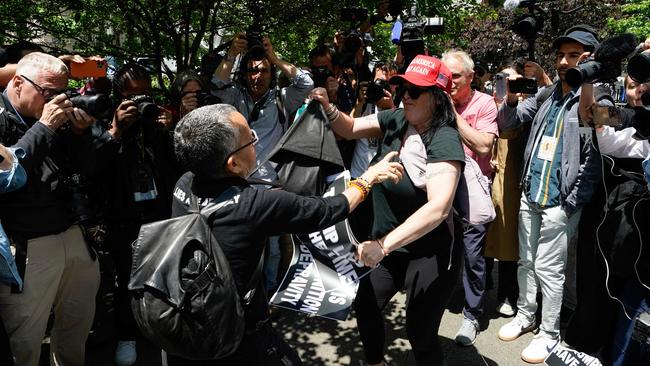 An anti-Trump protester and a pro-Trump supporter get into a dispute as they wait for a verdict. Picture: TIMOTHY A. CLARY / AFP
