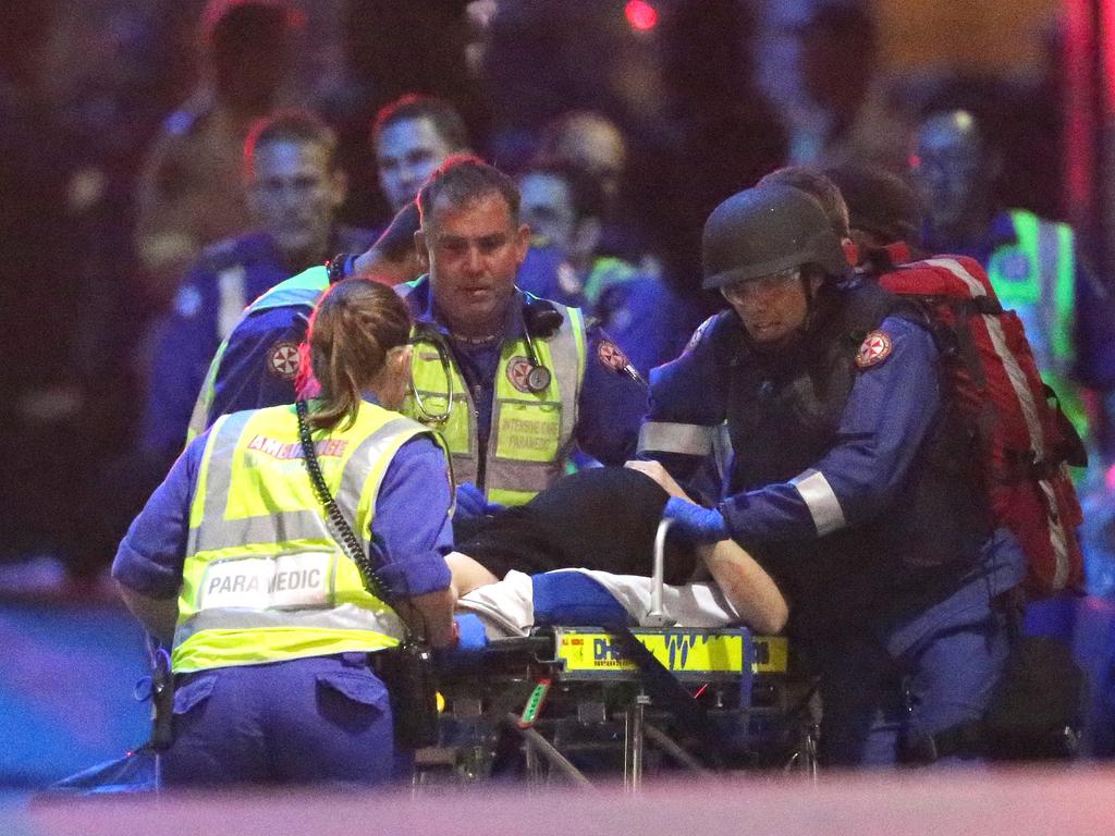 Emergency personnel wheel an injured hostage to an ambulance. Picture: Rob Griffith (AP)