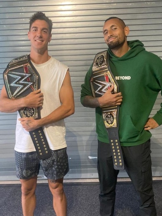 Thanasi Kokkinakis and Nick Kyrgios pose with WWE professional wrestling championship belts.