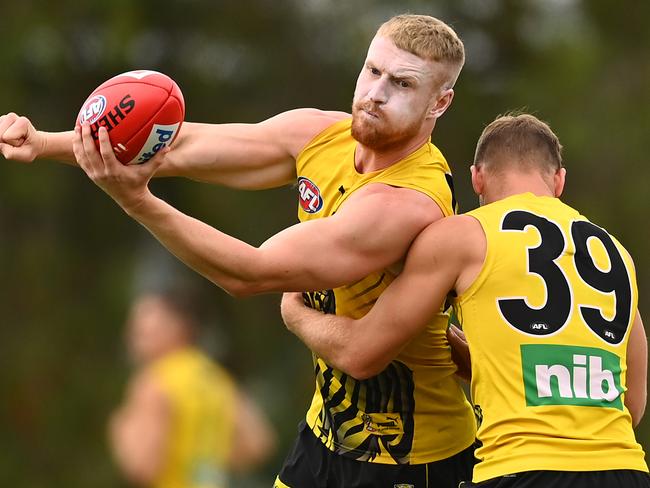 GOLD COAST, AUSTRALIA - SEPTEMBER 30: Josh Caddy of the Tigers handballs whilst being tackled by Jake Aarts of the Tigers during a Richmond Tigers AFL training session at Metricon Ovals on September 30, 2020 in Gold Coast, Australia. (Photo by Quinn Rooney/Getty Images)