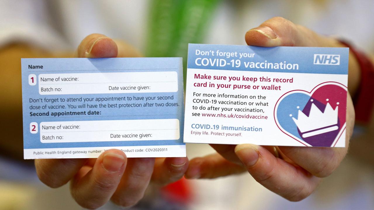 A model holds a card which will be given to British patients following their vaccination for COVID-19. Picture: AFP