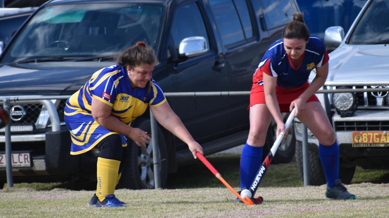 Townsville's Dulcie Reilly and Warwick's Danielle Cook battle for possession at the 2021 Queensland Hockey Women's Masters Championship at Queens Park.