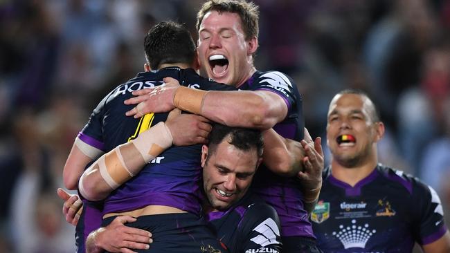 Billy Slater of the Storm is lifted by teammate Cameron Smith as he celebrates scoring a try during the NRL grand final between the Melbourne Storm and the North Queensland Cowboys at ANZ Stadium in Sydney, Sunday, October 1, 2017. (AAP Image/David Moir) NO ARCHIVING, EDITORIAL USE ONLY