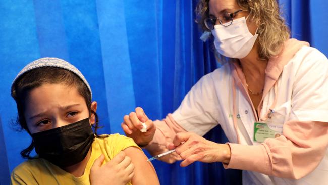 An Israeli health worker administers a dose of the Pfizer-BioNTech COVID-19 vaccine to a child at the Clalit Health Services in the central Israeli city of Modiin on January 2, 2022. (Photo by GIL COHEN-MAGEN / AFP)