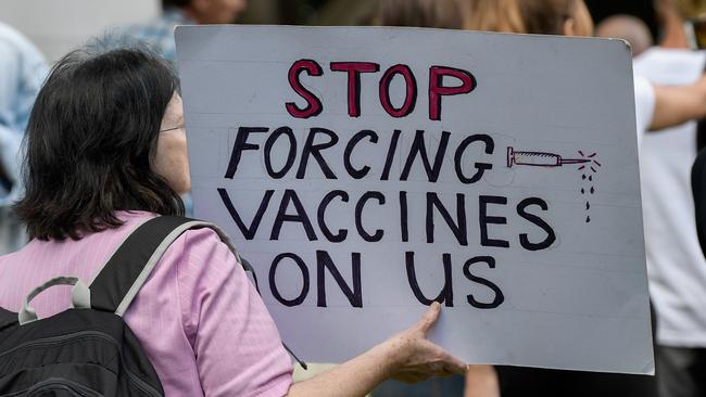 A protester holds up a placard during the 'Wake Up Australia!' march against mandatory vaccinations at Sydney’s Hyde Park in May. Picture: AAP