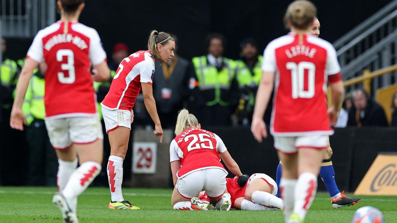 Arsenal players go to help Norwegian midfielder #12 Frida Maanum after she collapsed on the field.