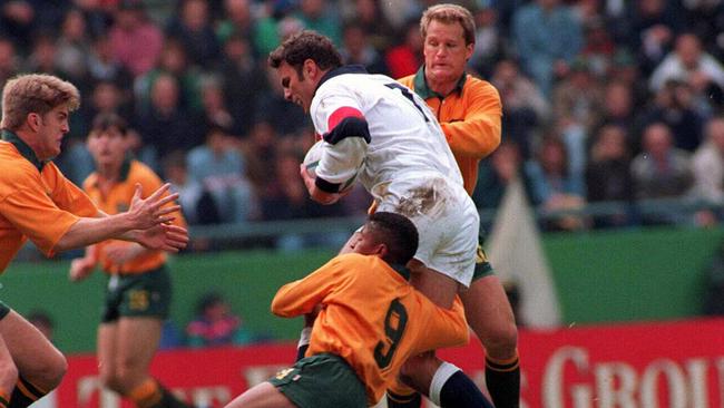 Tim Horan (left) comes in to assist Wallabies team mates George Gregan (no.9) and Michael Lynagh as they tackle England player Ben Clarke during their 1995 Rugby World Cup match. Picture: File