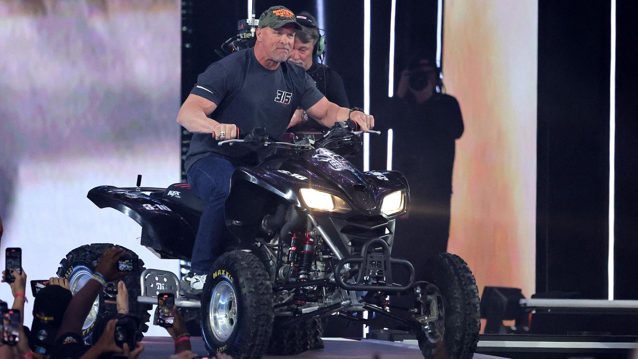 “Stone Cold” Steve Austin rides an ATV to the ring. (Photo by Ethan Miller/Getty Images via AFP)