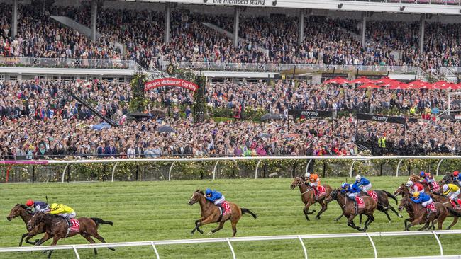 The Cup field thunders up the straight in front of a big crowd at Flemington on Tuesday. Picture: Jason Edwards