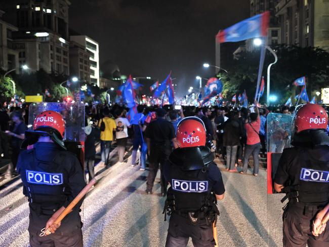 Malaysian police officers stand alert as opposition party supporters hold a rally in Putrajaya, Malaysia. Picture: AP