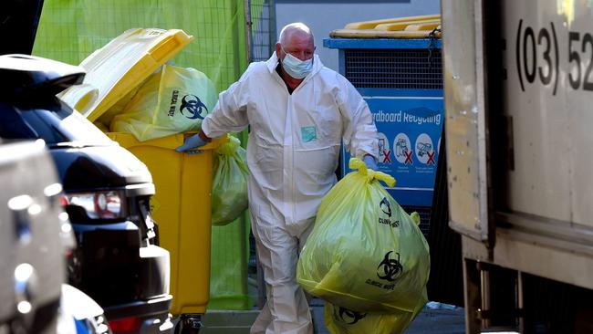 A worker removes medical waste from the aged care facility.