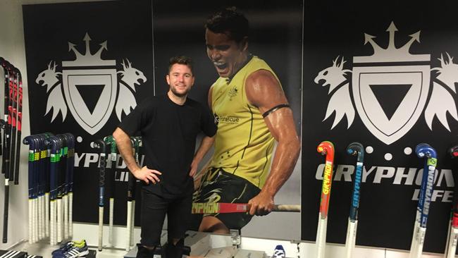 Oh brother! Leon Hayward stands next to a poster of younger brother Jeremy while on a hockey assignment in Belgium.