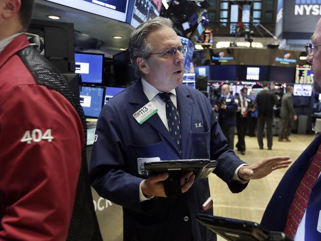 Traders Thomas Kaye, center, and Frederick Reimer confer on the floor of the New York Stock Exchange, Tuesday, Dec. 1, 2015. Stocks are slightly higher in early trading as investors look ahead to a busy week of economic reports and central bank meetings. (AP Photo/Richard Drew)
