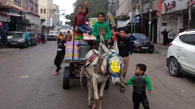 Children ride a donkey-pulled cart along a street in Rafah in the southern Gaza Strip on February 9, 2024. Picture: Mohammed Abed/AFP