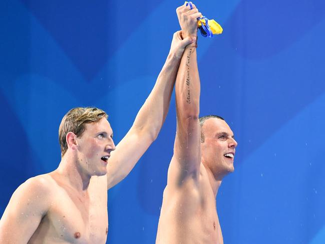 Australia's Kyle Chalmers (R gold) and Mack Horton (silver) of Australia celebrate after the swimming men's 200m freestyle final during the 2018 Gold Coast Commonwealth Games at the Optus Aquatic Centre in the Gold Coast on April 6, 2018 / AFP PHOTO / Anthony WALLACE