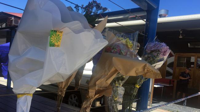 Floral tributes near the unit where the pair were found.