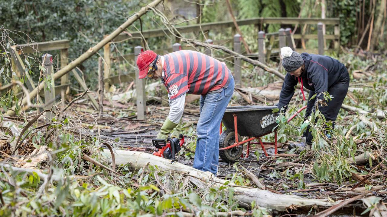 Locals Mary-Anne and Stewart Tyler clean up the mess. Picture: NCA NewsWire/Wayne Taylor