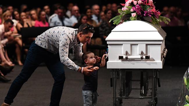 Hannah Clarke's brother Nat holds his son Tyler as he reaches for the coffin. (AAP Image/Dan Peled)