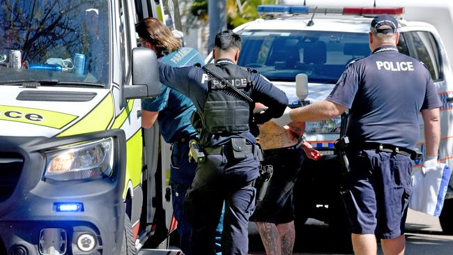 Police assist a man into an ambulance. Picture: Evan Morgan