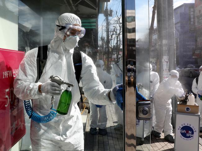 Disinfection professionals wearing protective gear spray antiseptic solution against the coronavirus in Seoul, South Korea. Picture: Chung Sung-Jun/Getty Images