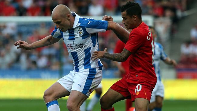 Aaron Mooy (L) of Huddersfield Town challenged by Philippe Coutinho.