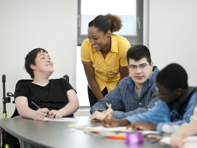 Diverse group of students with disabilities doing arts and crafts.