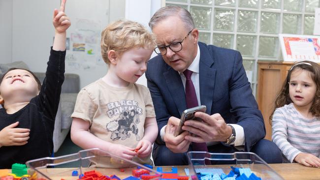 Anthony Albanese showing children a picture of his dog during a visit to the Manuka Childcare Centre. Picture: NewsWire / Gary Ramage