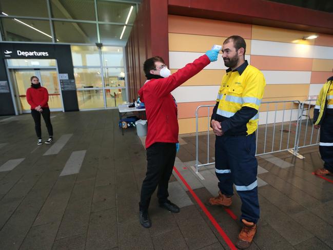 Rio Tinto FIFO workers have their temperatures taken before boarding a flight to a Pilbara mine site at Perth Airport. Experts believe temperature testing could become the norm for all flights in future. Picture: Danella Bevis/The West Australian