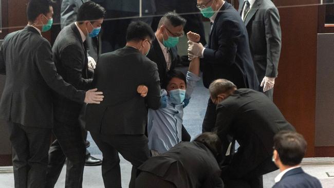 Ted Hui is removed by security during a scuffle with pro-Beijing legislators at the Legislative Council in Hong Kong in May last year. Picture: Getty Images