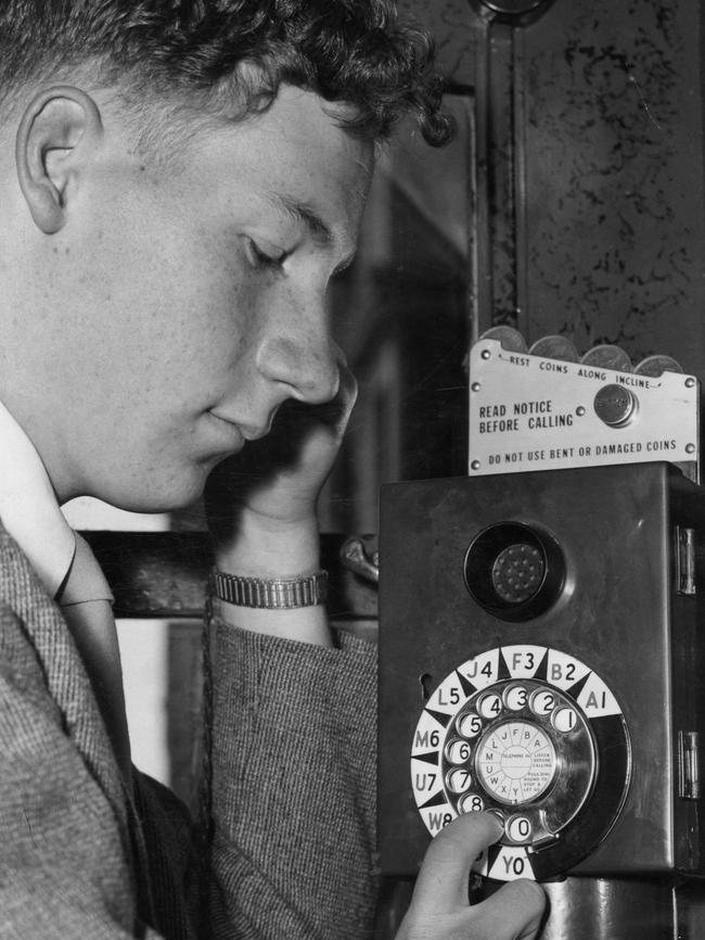 A man makes a phone call from a public phone in Adelaide in 1955.