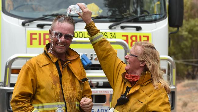 Husband and wife team Marcus and Deb Newlands from Woolsheds CFS cool off after fighting the Angle Vale fire on Friday. Picture: Naomi Jellicoe