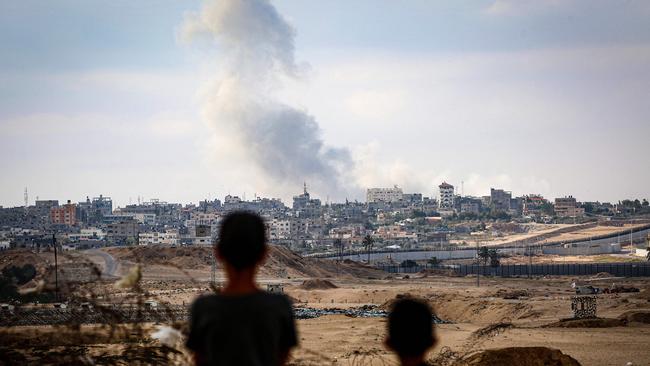 Boys watch smoke billowing during Israeli strikes east of Rafah in the southern Gaza Strip this week. Picture: AFP