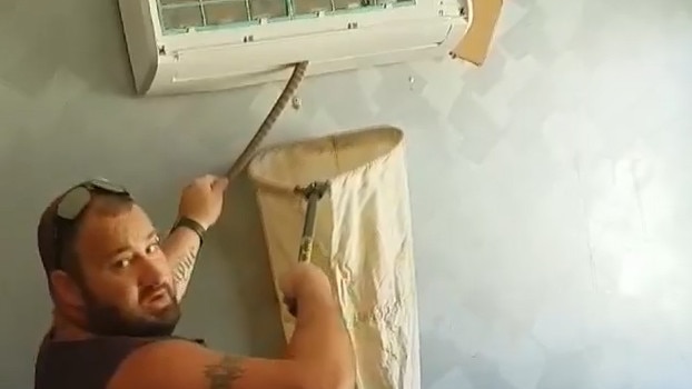 A Melbourne snake catcher pulls a name from an airconditioning unit in a Hoppers Crossing home. Courtesy: Natalie Marcok via Facebook.