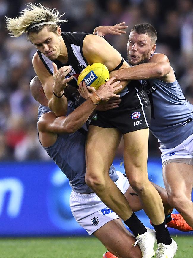 Brad Ebert and Sam Powell-Pepper tackle Darcy Moore during the Collingwood game where he received two knocks to the head. Picture: Quinn Rooney/Getty Images