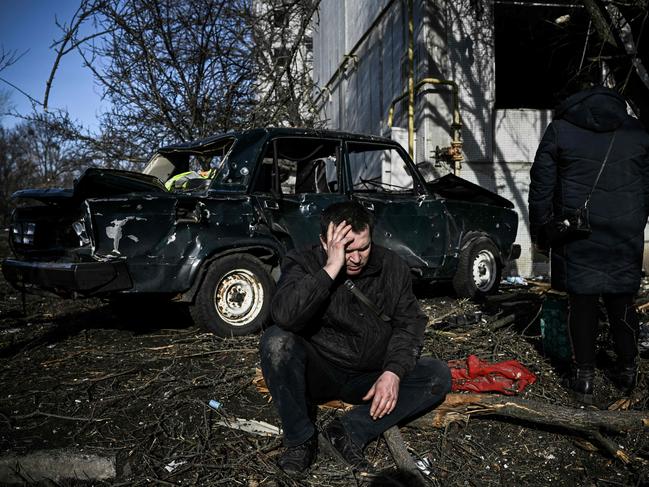 A man sits outside his destroyed home after bombings on the eastern Ukraine town of Chuguiv on February 24. Picture: AFP