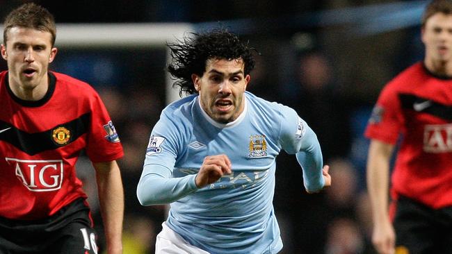 Manchester City's Carlos Tevez (C) keeps the ball as Manchester United's Michael Carrick (L) in 2010.
