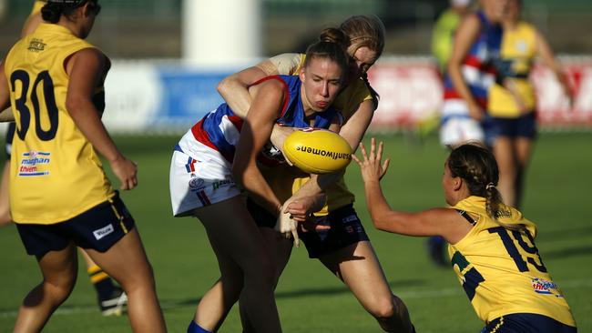 Central District’s player Amy Fisher gets a handball away while being tackled against the Eagles. Picture: Deb Curtis.