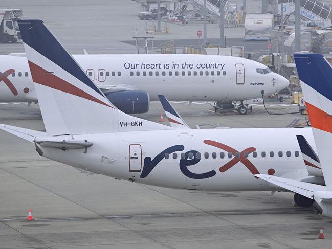 Rex Airlines Boeing 737 planes lay idle on the tarmac at Melbourne's Tullamarine Airport on July 31, 2024. The Australian regional airline Rex cancelled flights as it entered voluntary administration on July 31, leaving the fate of the country's third-largest carrier in serious doubt. (Photo by William WEST / AFP)