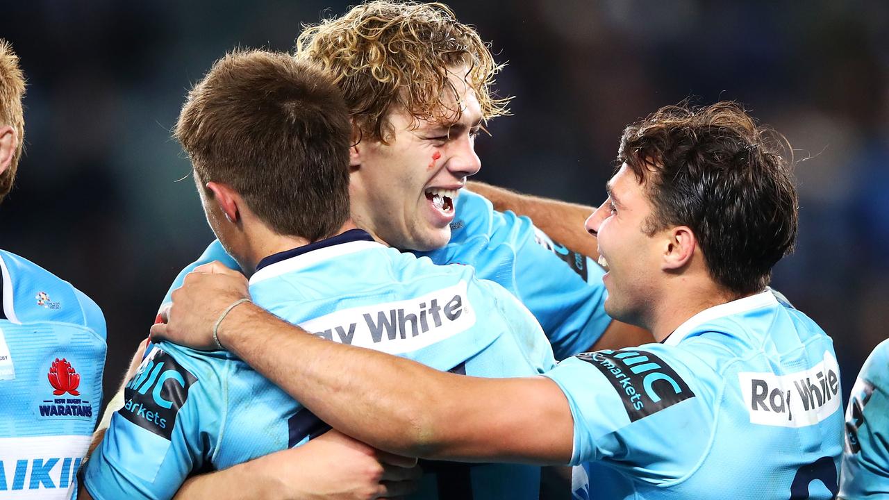 Alex Newsome, Ned Hanigan and Nick Phipps of the Waratahs celebrate victory.