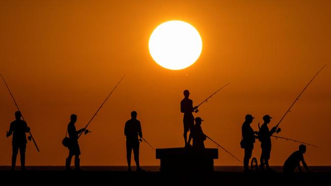 TOPSHOT - People fish at sunset on Havana's Malecon waterfront on July 6, 2023. The planet recorded its hottest day this week, reaching 17.18Â° Celsius. This record had already been broken last Monday. Scientists warn that this situation could be repeated on more occasions during 2023. (Photo by YAMIL LAGE / AFP)