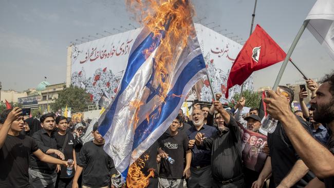 Iranians burn a representation of the Israeli flag during the funeral ceremony of Hamas leader Ismail Haniyeh. Picture: Majid Saeedi/Getty Images