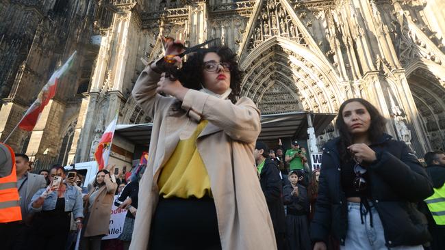 A protester is seen cutting her hair during the new protest against Islamic regime in Iran. Picture: Ying Tang/NurPhoto via Getty Images