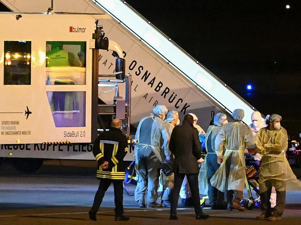 Medics wearing PPE are seen transporting a coronavirus patient from a MedEvac of the German armed forces Bundeswehr to an ambulance to move to another intensive care unit in the country. Picture: Ina Fassbender/AFP