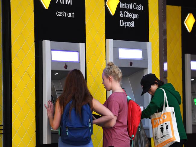 Customers use a Commonwealth Bank (CBA) ATM in Brisbane, Thursday, August 3, 2017. The Commonwealth Bank has been accused of a systemic failure to comply with anti-money laundering and counter-terrorism financing laws. The federal government's financial intelligence unit AUSTRAC on Thursday launched civil penalty proceedings in the Federal Court, accusing the lender of more than 53,700 contraventions of law. (AAP Image/Dan Peled) NO ARCHIVING