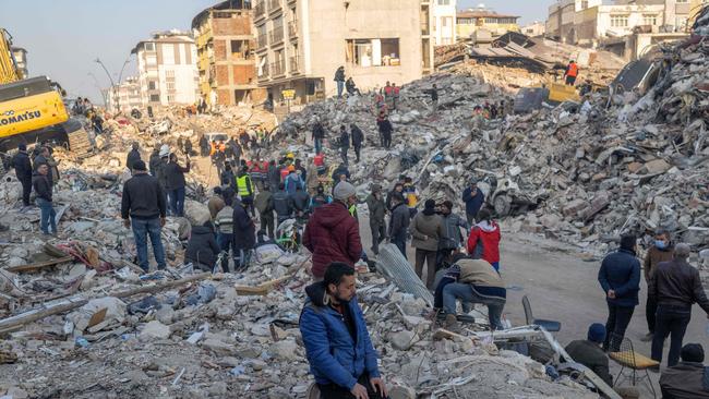 A man kneels on the rubble of a collapsed building during rescue operations. Picture: AFP