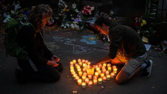 People light candles next to flowers and tributes laid in Christchurch. Picture: Carl Court/Getty Images