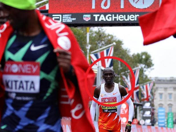 LONDON, ENGLAND - OCTOBER 04: Eliud Kipchoge of Kenya reacts as first place Shura Kitata of Ethiopia and second place Vincent Kipchumba of Kenya celebrate following the Elite MenÃ¢â¬â¢s race during the 2020 Virgin Money London Marathon around St. James's Park on October 04, 2020 in London, England. The 40th Race will take place on a closed-loop circuit around St. JamesÃ¢â¬â¢s Park in central London.  (Photo by Richard Heathcote/Getty Images)