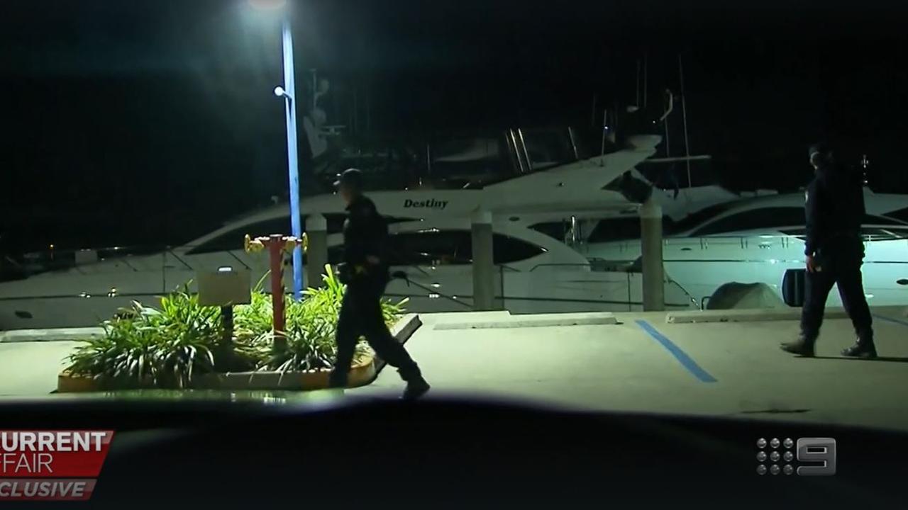 Police board the. luxury yacht to remove the seven voyagers into 14 day hotel quarantine. Picture: Channel 9/ACA